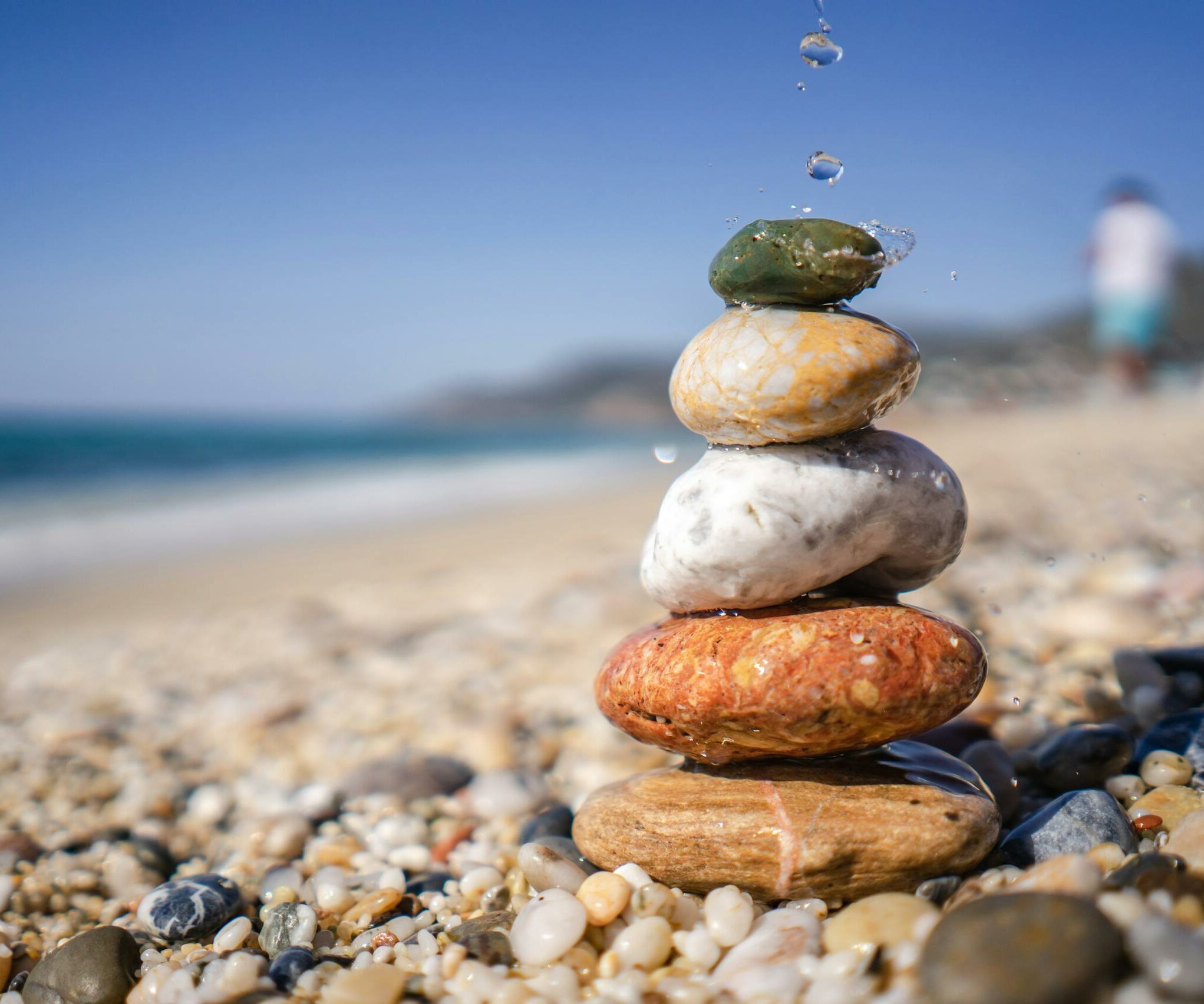 Close-up of stacked stones balancing on a serene pebble beach, symbolizing zen and stability.